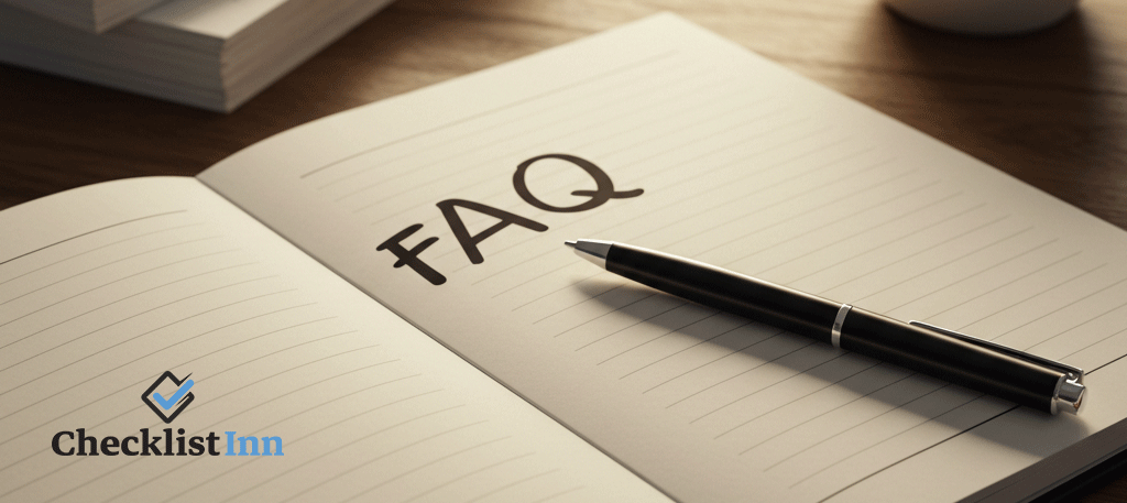 An open notebook with FAQ written at the top of the page, pen and papers on a desk in an office setting.